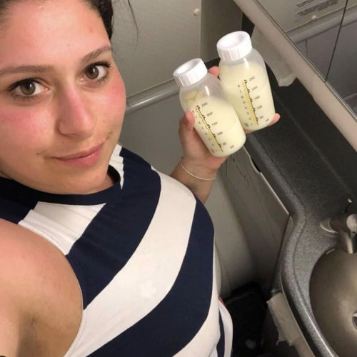 woman pumping breastmilk in airplane restroom
