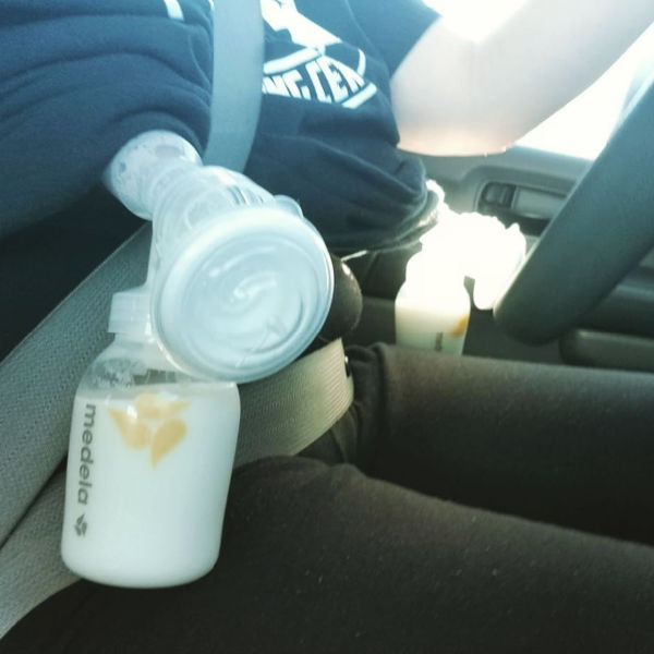 woman pumping in the driver's seat of a car with medela bottles and pump parts and seat belt on