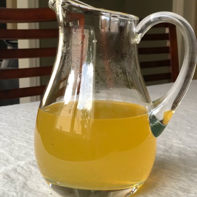 Lactation lemonade in aa clear pitcher on a white tablecloth