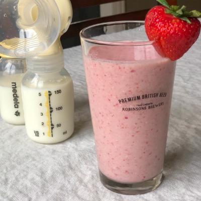 Strawberry Banana Lactation Smoothie with two medela bottles full of milk in the background