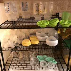 Three Tier Bottle Station - Black betty crocker three tier cooling rack set up as a drying rack with bottles and pump parts on it