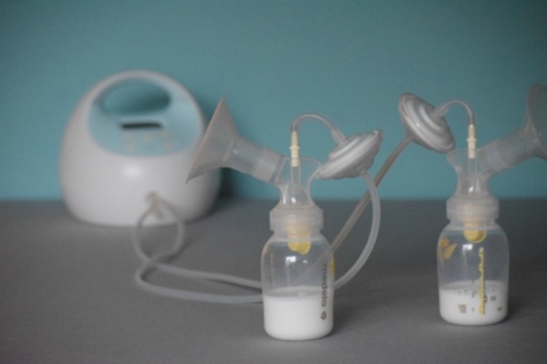 Spectra Medela Hack - A Spectra breast pump with a blue background; pump parts assembled to use Medela pump parts with a Spectra backflow protector