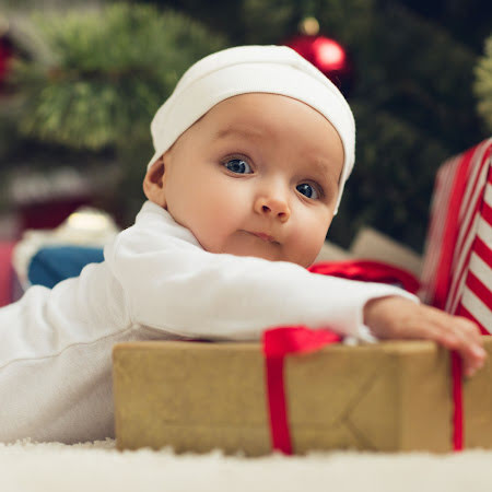baby with a christmas present holiday pumping guide