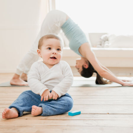 woman doing yoga with baby in foreground