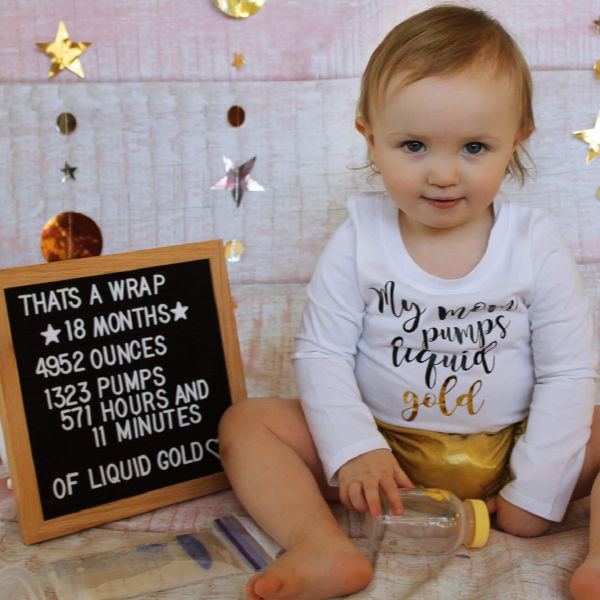 Pumping photoshoot: Baby sitting next to a letterboard listing pumping accomplishments