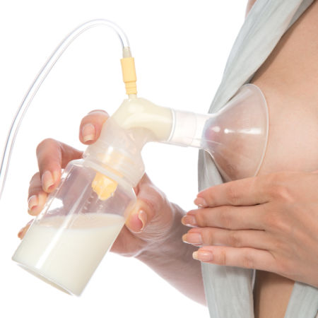 woman pumping breast milk and doing breast compressions