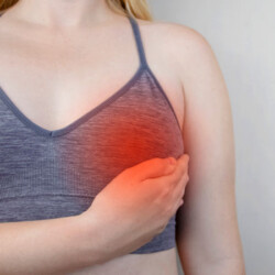 woman holding breast in pain