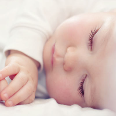baby on side sleeping on a white background