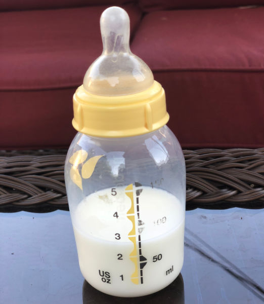 Medela bottle on a table with nipple attached