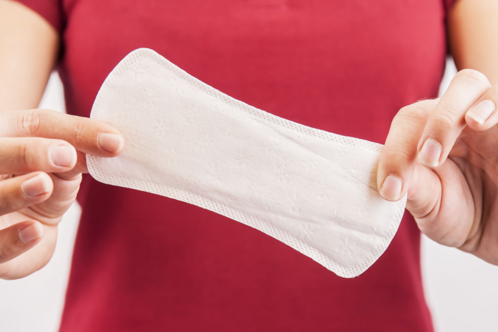 woman holding a sanitary napkin for menstruationn