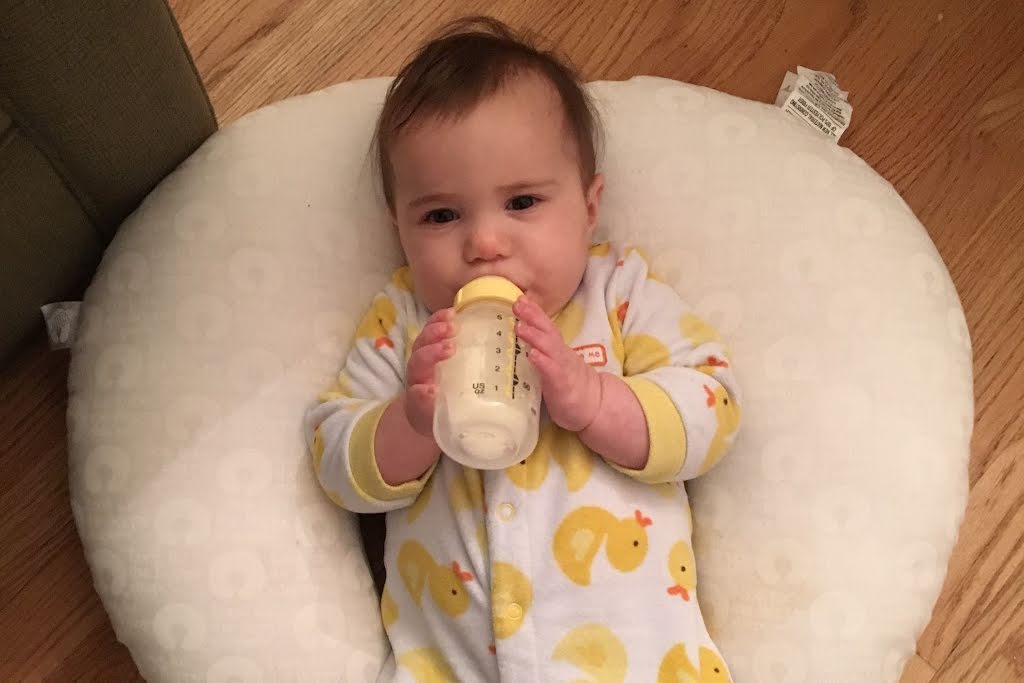 baby drinking a bottle of breast milk