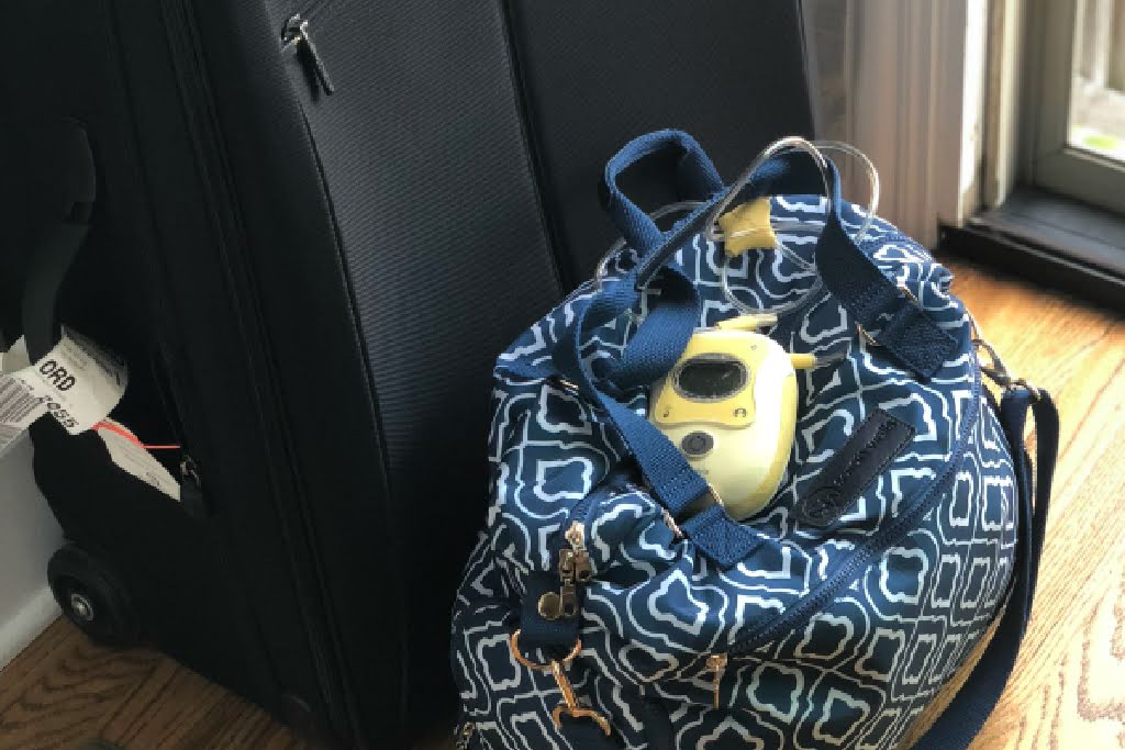 breast pump and breast pump bag next to suitcase