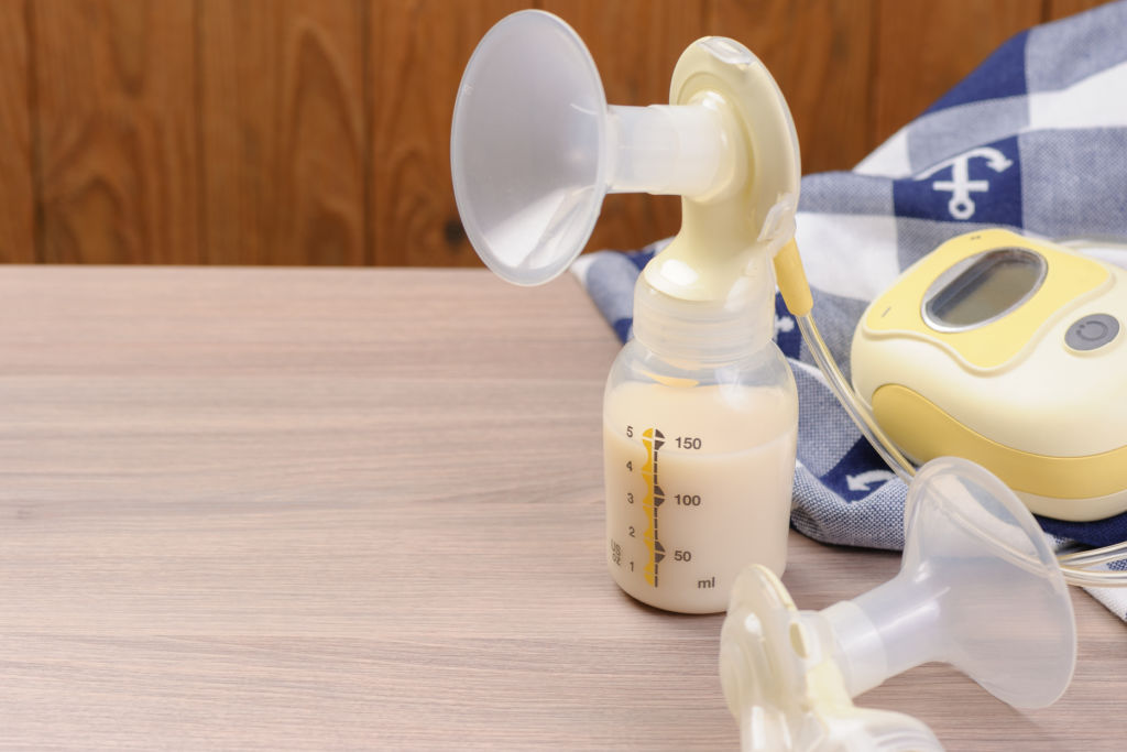 breast pump parts with breast milk in bottles