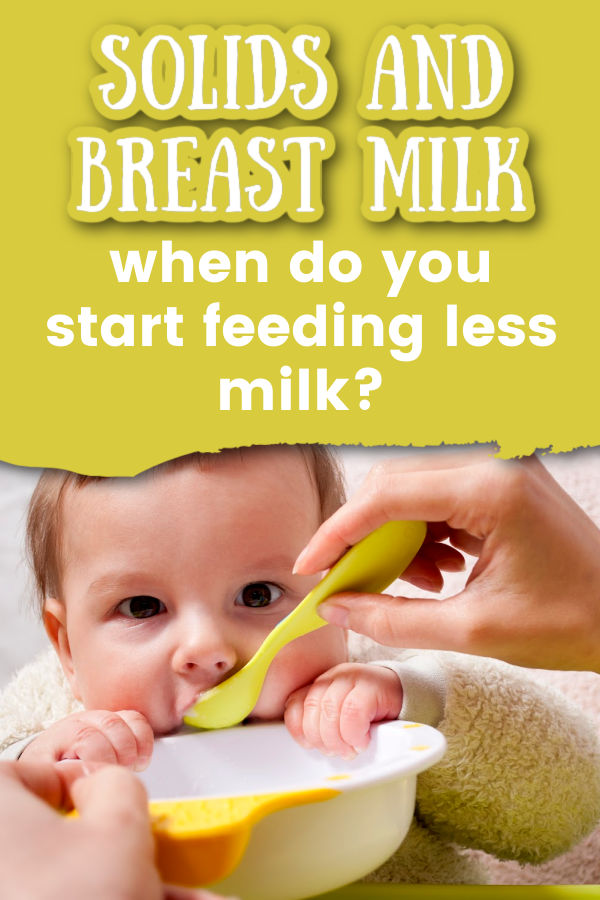 baby being spoon fed solids with text overlay solids and breast milk when do you start feeding less milk?
