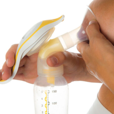 Mother getting milk with a manual breast pump isolated on a white background
