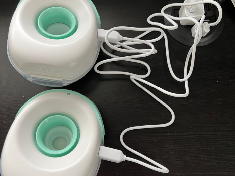 Two Willow Go breast pumps charging on a black surface