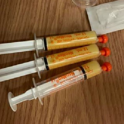 Three syringes holding colostrum sitting on a table