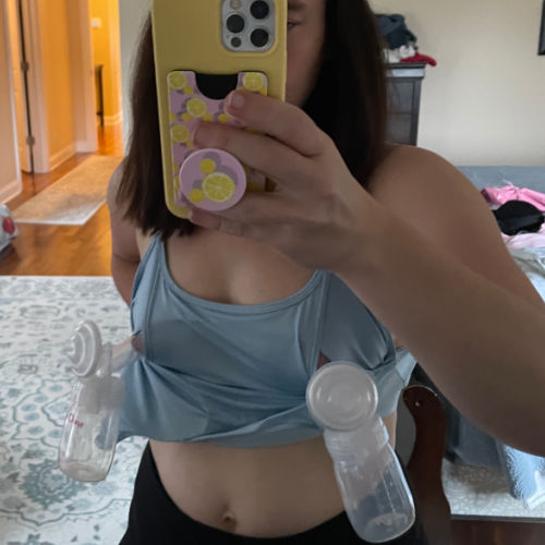 woman wearing blue Sweat and Milk Oceane nursing sports bra set up for hands-free pumping