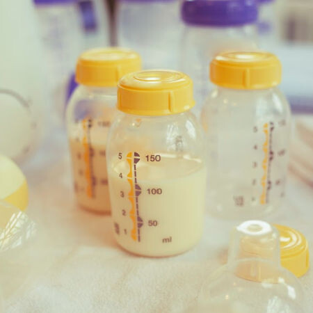 Medela breast milk bottles in front of a breast pump